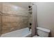 Tiled bathtub and shower combination with built-in shelves and neutral-patterned shower curtain at 4780 Woodruff Trce, Cumming, GA 30028