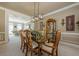 Open-concept dining area with modern chandelier and view into the adjacent living room at 4780 Woodruff Trce, Cumming, GA 30028