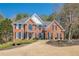 Charming two-story red brick home with black shutters and a well-manicured lawn and landscaped front yard at 4780 Woodruff Trce, Cumming, GA 30028