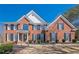 Stunning two-story brick home with black shutters, lush landscaping, and a welcoming front entrance at 4780 Woodruff Trce, Cumming, GA 30028