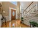 Elegant foyer with hardwood floors, a grand staircase, and a stylish front door with decorative glass at 4780 Woodruff Trce, Cumming, GA 30028