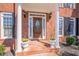 Inviting front porch featuring classic columns, a beautiful wood door, and decorative potted plants at 4780 Woodruff Trce, Cumming, GA 30028