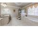 Bright bathroom featuring a soaking tub, granite countertops, and tiled floors at 4780 Woodruff Trce, Cumming, GA 30028