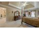 Bright main bedroom featuring neutral decor, a four-poster bed, and access to the ensuite bath at 4780 Woodruff Trce, Cumming, GA 30028