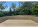 Large grassy backyard with a newly constructed wooden deck surrounded by mature trees at 1066 Cleavemark Dr, Clarkston, GA 30021