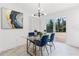 Bright dining room featuring a glass table, blue chairs, and a modern light fixture at 1066 Cleavemark Dr, Clarkston, GA 30021