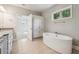 A bathroom featuring a soaking tub, a vanity and large windows at 1112 Central Park Rd, Decatur, GA 30033