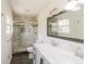 Modern bathroom featuring double sinks, marble countertops, and a glass-enclosed shower with marble tiling at 2330 Lago Dr, Jonesboro, GA 30236
