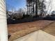 Large backyard with a wooden fence, grassy area, and the exterior of the home at 2716 Wynford Sw Ave, Marietta, GA 30064