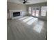 Open living room with brick fireplace, ceiling fan, and natural light, complemented by gray luxury vinyl plank flooring at 2716 Wynford Sw Ave, Marietta, GA 30064