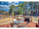 Back deck with outdoor seating and a grill overlooks the yard and surrounding trees at 3280 Spincaster Way, Loganville, GA 30052