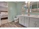 Bathroom boasting a double vanity, wood-look floors, and decorative mirrors at 3280 Spincaster Way, Loganville, GA 30052