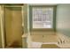 Bathroom boasts a shower and soaking tub in front of the window at 3280 Spincaster Way, Loganville, GA 30052