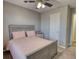 Bedroom with gray paneled bed, ceiling fan and curtains at 3280 Spincaster Way, Loganville, GA 30052