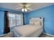 Bedroom with a fan, neutral carpet, and bright blue walls at 3280 Spincaster Way, Loganville, GA 30052