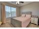 Cozy bedroom featuring a full bed, ceiling fan, and large window with neutral color scheme at 3280 Spincaster Way, Loganville, GA 30052
