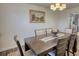 Dining room with stylish lighting, wood floors, and view into modern kitchen at 3280 Spincaster Way, Loganville, GA 30052