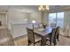 Spacious dining room with modern lighting, wood floors, and staircase to upper level at 3280 Spincaster Way, Loganville, GA 30052