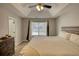 Bright main bedroom with tray ceiling, large window, and neutral color scheme at 3280 Spincaster Way, Loganville, GA 30052