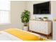 Comfortable bedroom featuring a modern dresser, TV, and a large plant at 5352 Beaver Br, Norcross, GA 30071
