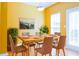 Bright dining room featuring a wood table set for six, complemented by yellow walls and natural light at 5352 Beaver Br, Norcross, GA 30071