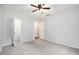 A bright bedroom with light-colored walls, gray carpet, ceiling fan, and two open doorways at 1510 Gettysburg Pl, Atlanta, GA 30350