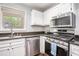 Bright kitchen with white cabinets, stainless steel appliances, and granite counters at 1510 Gettysburg Pl, Atlanta, GA 30350