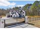 Striking two-story home with black trim, gated driveway, and an attached three car garage at 3057 Bold Springs Rd, Dacula, GA 30019