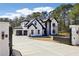 A grand two-story home with a gated entrance, a three-car garage, and mature trees at 3057 Bold Springs Rd, Dacula, GA 30019