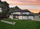 Elegant home exterior with a well-manicured lawn and a beautiful sunset backdrop at 3057 Bold Springs Rd, Dacula, GA 30019