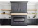 Modern fireplace features stone detailing, floating wood shelves, black cabinets, and electric fireplace at 3057 Bold Springs Rd, Dacula, GA 30019
