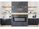 Close up of a modern fireplace with floating shelves and sleek black cabinetry at 3057 Bold Springs Rd, Dacula, GA 30019
