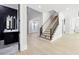 Foyer with wood floors, a staircase, and a half bathroom featuring dark vanity with marble floors at 3057 Bold Springs Rd, Dacula, GA 30019