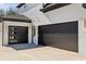 Modern three-car garage with sleek black doors and exterior lighting fixtures at 3057 Bold Springs Rd, Dacula, GA 30019