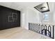 Hallway with a modern light fixture, wood floors, and black accent wall panels at 3057 Bold Springs Rd, Dacula, GA 30019