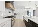 Bright kitchen with white cabinets, a gas range, and a large island with a farmhouse sink at 3057 Bold Springs Rd, Dacula, GA 30019