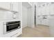 Close up of kitchen nook with a microwave, cabinets, and quartz countertop, next to a walk-in pantry at 3057 Bold Springs Rd, Dacula, GA 30019