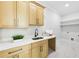 Well-lit laundry room with wooden cabinets, quartz countertops, and a sink at 3057 Bold Springs Rd, Dacula, GA 30019