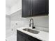 Well-organized laundry room with dark cabinets and a stainless steel sink at 3057 Bold Springs Rd, Dacula, GA 30019