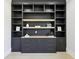 Office space featuring built-in dark shelving, storage cabinets, drawers and light wood floors at 3057 Bold Springs Rd, Dacula, GA 30019