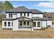 Back exterior view of a house featuring a covered patio and well-maintained landscaping at 3057 Bold Springs Rd, Dacula, GA 30019