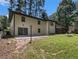 Spacious backyard with brick patio, grassy area, tall trees, and wooden deck at 546 Milligan Dr, Stone Mountain, GA 30083