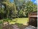 Expansive backyard featuring a wooden deck, lush lawn, and mature trees offering shade and privacy at 546 Milligan Dr, Stone Mountain, GA 30083