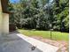 Lush green backyard with mature trees, complemented by a concrete patio for outdoor living at 546 Milligan Dr, Stone Mountain, GA 30083