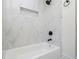 The tiled shower and tub combo features a sleek design with recessed shelving at 546 Milligan Dr, Stone Mountain, GA 30083
