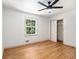 Bright bedroom features hardwood floors, a ceiling fan, large window, and closet at 546 Milligan Dr, Stone Mountain, GA 30083