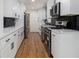 Modern kitchen with white cabinets, stainless appliances, black subway tile and updated lighting at 546 Milligan Dr, Stone Mountain, GA 30083