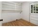Laundry room with hardwood floors, white shelving and exterior door at 546 Milligan Dr, Stone Mountain, GA 30083