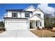 Charming two-story home featuring white siding, black shutters, and a spacious two-car garage at 660 Redhead Way (Lot 24), Grayson, GA 30017