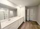 Bright bathroom featuring double sink vanity, modern finishes, wood-look flooring, and glass door shower at 660 Redhead Way (Lot 24), Grayson, GA 30017